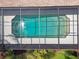 Overhead shot of screened-in pool with crystal clear water, surrounded by green yard at 14170 Fennsbury Dr, Tampa, FL 33624