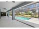 A screened in pool with clean blue water is surrounded by a deck and outdoor ceiling fans at 14170 Fennsbury Dr, Tampa, FL 33624