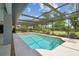 A screened in pool with clean blue water is surrounded by a deck and a grassy yard at 14170 Fennsbury Dr, Tampa, FL 33624