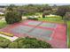 Aerial view of community tennis courts with green trees, lush greenery, and fenced perimeter at 14170 Fennsbury Dr, Tampa, FL 33624