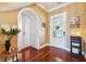 Elegant foyer showcasing an archway, decorative front door, and gleaming hardwood floors at 15936 Ternglade Dr, Lithia, FL 33547