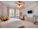 A bedroom featuring pink curtains, white shutters, and a decorative ceiling fan with light fixture at 16170 Colchester Palms Dr, Tampa, FL 33647