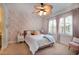 A bedroom features floral wallpaper, pink curtains, and a bed with multiple pillows at 16170 Colchester Palms Dr, Tampa, FL 33647