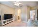 Neutral toned bedroom features a television, ceiling fan, and ensuite bathroom at 16170 Colchester Palms Dr, Tampa, FL 33647