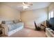 Neutral toned bedroom features a bed, gaming equipment, and a ceiling fan at 16170 Colchester Palms Dr, Tampa, FL 33647