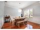 Dining room with a wooden table, stylish wallpaper, modern lighting, and a large window with shutters at 16170 Colchester Palms Dr, Tampa, FL 33647