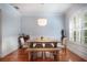 Bright dining room with wooden table and bench, stylish wallpaper, and a modern pendant light fixture at 16170 Colchester Palms Dr, Tampa, FL 33647