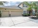 Beige two-story home boasting a three-car garage and well-maintained landscaping at 16170 Colchester Palms Dr, Tampa, FL 33647