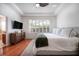 A bedroom with a ceiling fan, shutters, hardwood floors and access to the bathroom at 16170 Colchester Palms Dr, Tampa, FL 33647