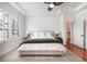 A bedroom with trey ceilings, shutters, hardwood floors and a ceiling fan at 16170 Colchester Palms Dr, Tampa, FL 33647
