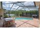 Outdoor pool area with screened enclosure, brick patio, and dining set at 16170 Colchester Palms Dr, Tampa, FL 33647