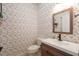 Stylish powder room with patterned wallpaper, a modern vanity, and elegant fixtures for a charming look at 16170 Colchester Palms Dr, Tampa, FL 33647