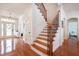 Elegant staircase with wooden steps, an iron railing, and white trim in a bright, open entryway at 16170 Colchester Palms Dr, Tampa, FL 33647