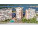 Overhead view of beachfront buildings with pool, landscaping, and surrounding waterways, providing a serene coastal living experience at 17920 Gulf Blvd # 208, Redington Shores, FL 33708