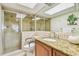 Bathroom features a granite countertop, wooden cabinets, and tiled walk-in shower with a glass door at 17920 Gulf Blvd # 208, Redington Shores, FL 33708