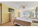 Bedroom with light wood laminate, balcony view, fan, mounted TV, and adjacent sitting area at 17920 Gulf Blvd # 208, Redington Shores, FL 33708