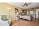 Large bedroom featuring a fan, pale yellow walls, laminate flooring, chair, and large bed at 17920 Gulf Blvd # 208, Redington Shores, FL 33708