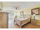 Cozy bedroom with ceiling fan, pale yellow walls, balcony access, and light wood-style laminate flooring at 17920 Gulf Blvd # 208, Redington Shores, FL 33708