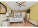 Bedroom with a light fan, pale yellow walls, wood-style laminate flooring, and a dresser at 17920 Gulf Blvd # 208, Redington Shores, FL 33708