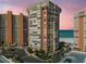 A high-rise condo building overlooks the ocean with lush landscaping and plenty of parking spaces at 17920 Gulf Blvd # 208, Redington Shores, FL 33708