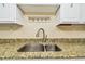 Close-up of kitchen sink with granite countertops, white cabinets, and stainless steel faucet at 17920 Gulf Blvd # 208, Redington Shores, FL 33708