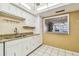 Bright kitchen featuring a pass-through to a living room, granite countertops, and white cabinets at 17920 Gulf Blvd # 208, Redington Shores, FL 33708