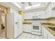Bright kitchen with white cabinets, granite countertops, white appliances, and tiled floor at 17920 Gulf Blvd # 208, Redington Shores, FL 33708