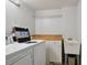 Functional laundry room with washer, dryer, utility sink, and storage, designed for convenient household tasks at 17920 Gulf Blvd # 208, Redington Shores, FL 33708