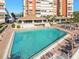Community outdoor pool with lounge seating and an adjacent entertainment area at 17920 Gulf Blvd # 208, Redington Shores, FL 33708