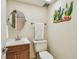 Charming powder room with round mirror, cute sea decor, and neutral beige walls at 17920 Gulf Blvd # 208, Redington Shores, FL 33708