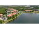 Aerial view showcases the condo buildings, a swimming pool, community center, and landscaping by the lake at 18107 Peregrines Perch Pl # 6303, Lutz, FL 33558