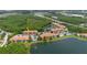 Aerial view of lakeside condo community with tennis court, parking, and natural wooded backdrop at 18107 Peregrines Perch Pl # 6303, Lutz, FL 33558