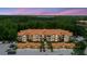 An aerial view of the condos shows a tiled roof, trees in the back, plenty of parking and lovely landscaping at 18107 Peregrines Perch Pl # 6303, Lutz, FL 33558