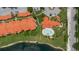 An aerial view of the condo buildings, community pool, landscaping, and lake at 18107 Peregrines Perch Pl # 6303, Lutz, FL 33558