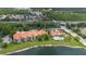 Scenic aerial view of lakeside condos and clubhouse with pool, lush landscaping, and ample parking at 18107 Peregrines Perch Pl # 6303, Lutz, FL 33558
