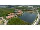 Aerial view of condo complex showcasing scenic waterfront views, lush landscaping, and surrounding woodlands at 18107 Peregrines Perch Pl # 6303, Lutz, FL 33558