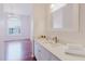 Bright bathroom featuring a white vanity with modern fixtures, a decorative mirror, and stacked white towels at 18107 Peregrines Perch Pl # 6303, Lutz, FL 33558