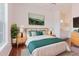 Staged bedroom with a large bed and decorative art and furnishings at 18107 Peregrines Perch Pl # 6303, Lutz, FL 33558