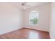 Simple bedroom with hardwood floors, a ceiling fan, and a bright window at 18107 Peregrines Perch Pl # 6303, Lutz, FL 33558