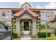 Close-up of the front entrance to the condos with tiled roof, handicap parking, and beautiful landscaping at 18107 Peregrines Perch Pl # 6303, Lutz, FL 33558