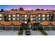 Lovely condo exterior with garages, a tiled roof, neat landscaping, and plenty of parking spots at 18107 Peregrines Perch Pl # 6303, Lutz, FL 33558