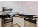 Well-lit kitchen with white cabinetry, granite counters, and stainless steel appliances at 18107 Peregrines Perch Pl # 6303, Lutz, FL 33558