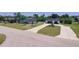 Birds eye view of a home with U driveway and separate garage on a sunny day at 20295 Lorenzo Ave, Port Charlotte, FL 33952