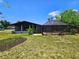A well-maintained yard with a screened lanai and lush landscaping creating a private oasis at 20295 Lorenzo Ave, Port Charlotte, FL 33952