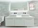 Modern bathroom features a double sink vanity with sleek white cabinetry, stylish faucets, and a well-lit mirror at 20295 Lorenzo Ave, Port Charlotte, FL 33952