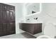 Bathroom featuring a modern floating vanity with double sinks, LED mirror, and a nearby dark wood door at 20295 Lorenzo Ave, Port Charlotte, FL 33952