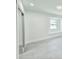 Bright bedroom featuring modern tile flooring, closet with mirrored doors, and natural light from window at 20295 Lorenzo Ave, Port Charlotte, FL 33952