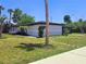 Ranch home with white exterior, black trim, green grass, and landscaping at 20295 Lorenzo Ave, Port Charlotte, FL 33952