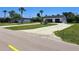 Property featuring a well-maintained home, detached garage, and a spacious, sunny front yard at 20295 Lorenzo Ave, Port Charlotte, FL 33952