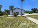 Property showcasing a well-maintained home, mature trees, and lush landscaping in a quiet neighborhood at 20295 Lorenzo Ave, Port Charlotte, FL 33952